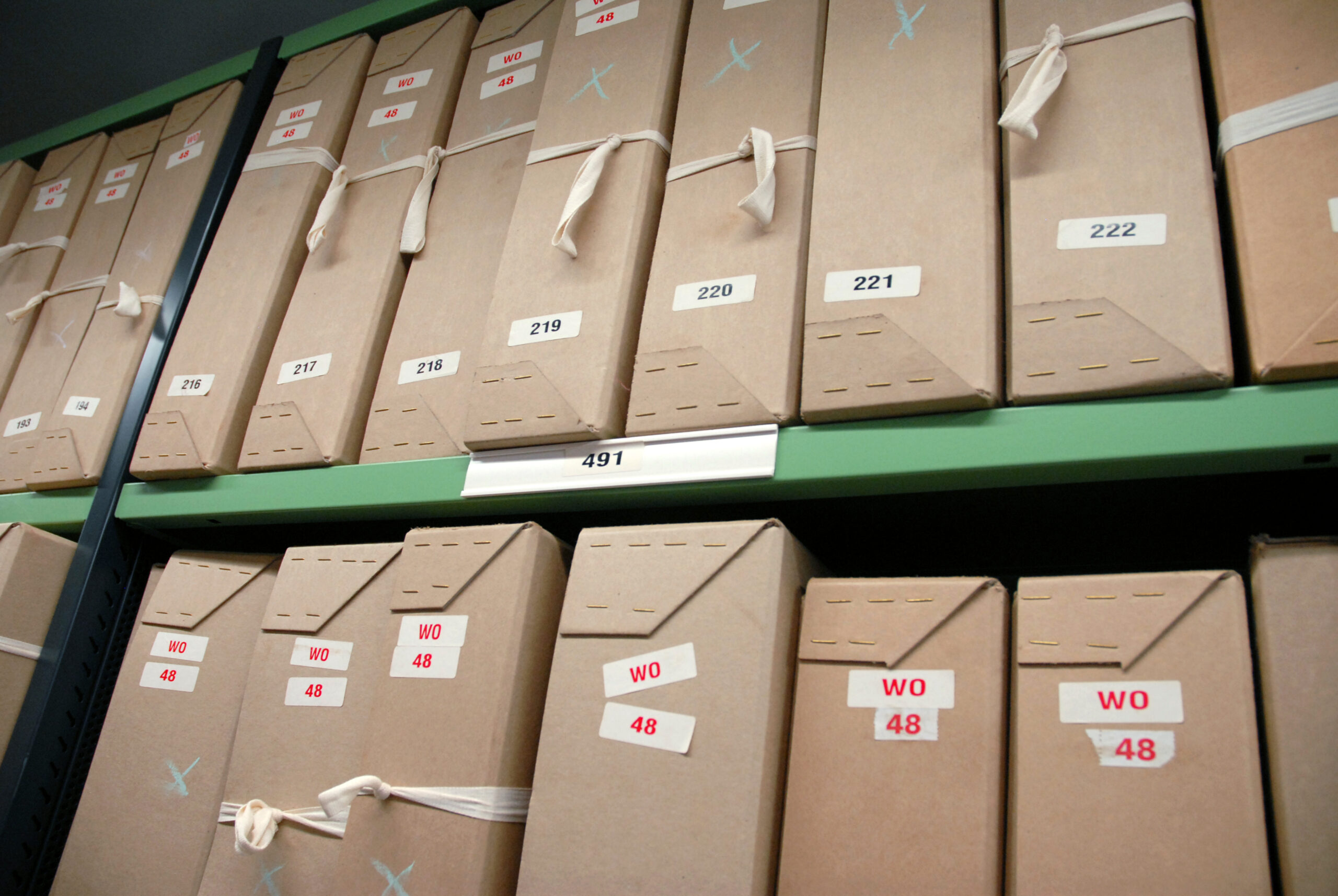 Rows of labeled archive boxes stored on metal shelving at The National Archives.